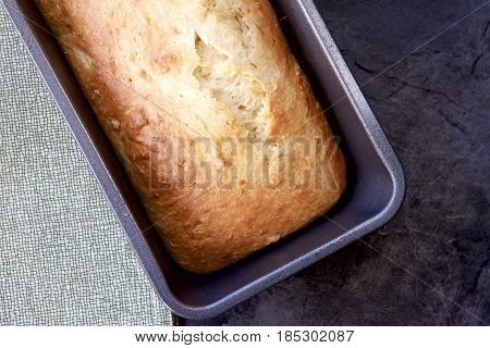 Hot fresh banana bread in a tin from the oven.
