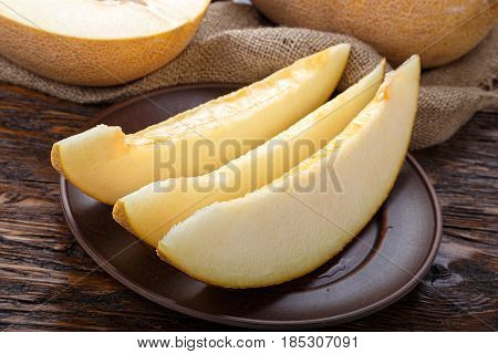 juicy ripe cut melon on a dark brown table