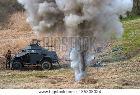 Gatchina Russia - May 7 2017: Historical reconstruction of the battles of World War II. Combat with an armored personnel carrier. In the foreground explosion of mines.