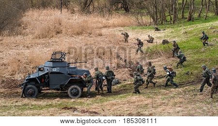Gatchina Russia - May 7 2017: Historical reconstruction of the battles of World War II. Attack of the German soldiers. In combat an armored personnel carrier is used.