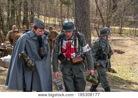 Gatchina Russia - May 7 2017: Historical reconstruction of the battles of World War II. Participants in the reconstruction. In the foreground are German soldiers of the communications and sanitary service.