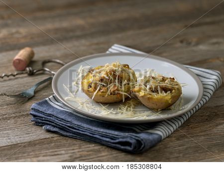 Served potion of baked potato stuffed with mushrooms and plenty of cheese, blue towel