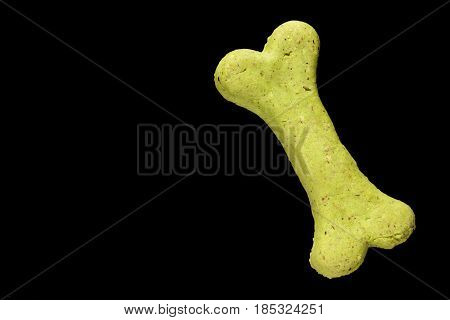 Dog biscuit on black background to connote a concept of feeding animals