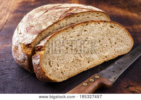 Freshly backed Farmhouse Bread sliced as close-up on an old burnt cutting board