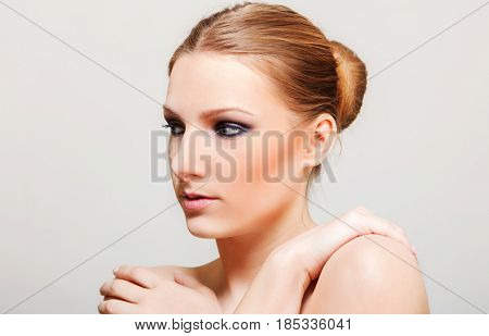 Attractive blonde topless woman with dark eye make up