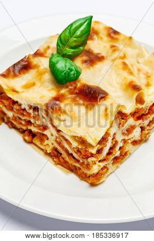 Portion of tasty lasagn, isolated on white background