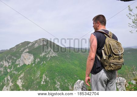 Hiker on top of a mountain enjoy the beautiful view of nature, and mountain on the other side of the canyon. View on mountain Kablar, Serbia