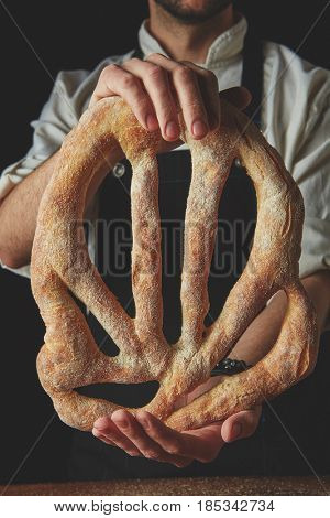 Baker holding fougas bread