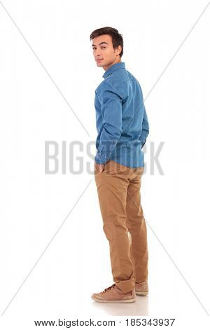 full body picture of a casual man looking back over his shoulder on white background, back view