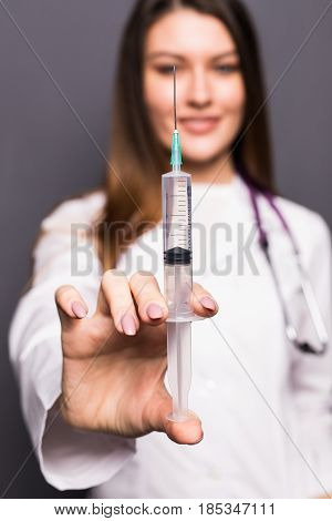 Young Doctor Woman With Syringe On Grey Background