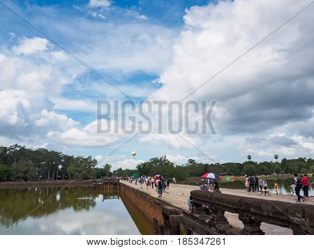 Siem Reap Cambodia - October 30 2016: Tourists walking back along the stone bridge after visiting Angkor Wat UNESCO World Heritage site in Cambodia