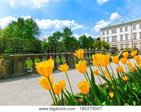 The people going at the beautiful Mirabell gardens in Salzburg. It is a popular destination visited by tourists at Salzburg, Austria