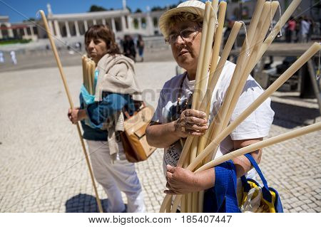 Fatima Portugal - May 13 2014: Woman holding candles to pay a promise at the Sanctuary of Fatima during the celebrations of the apparition of the Virgin Mary in Fatima Portugal.
