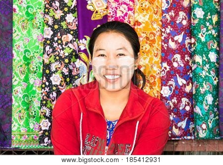 MINGUN,MYANMAR - MARC 6, 2017:Unidentified young Myanmar woman with thanaka on her smile face is happiness in Mingun on March 6, 2017. Thanaka is a yellowish-white cosmetic paste made from ground bark