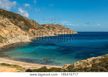 Lighthouse and beach at Revellata near Calvi in the Balagne region of Corsica with clear turquoise Mediterranean sea and blue sky