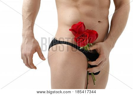 Handsome man holding a red rose and a bouquet of red roses. Sexy man gives a rose on a white background with a beautiful light. Isolated on white background