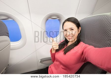 Middle aged women smie and selfie in the airplane