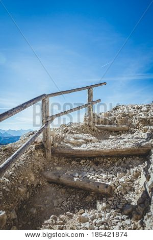 Stairs on an alpine trekking route seemingly leading to the heavens with vivid blue skies.