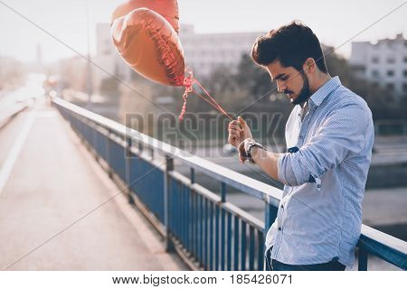 Sad unhappy man waiting for girlfriend on valentine date