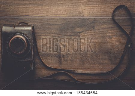 wooden background with retro still camera in case