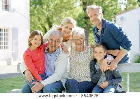 Portrait of intergenerational family sitting on bench
