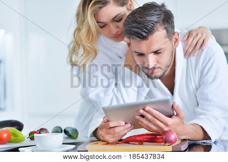 Happy couple cooking breakfast together in the kitchen.