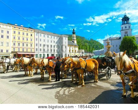 Central place in Salzburg city , Austria with carriages and horses
