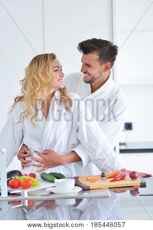 Happy couple cooking breakfast together in the kitchen.