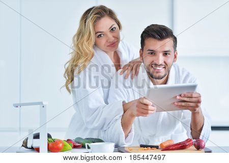 Happy couple cooking breakfast together in the kitchen.
