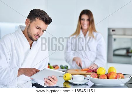 Happy couple cooking breakfast together in the kitchen.