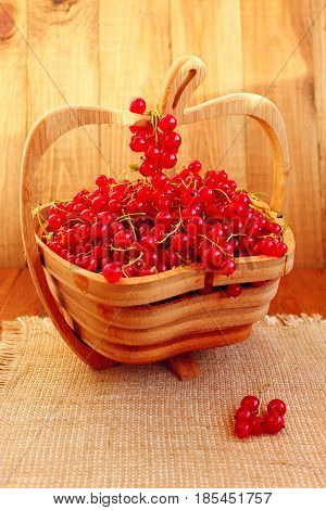 clusters of fresh ripe berries of red currant on the wooden vase