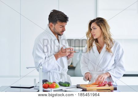 Happy couple cooking breakfast together in the kitchen.