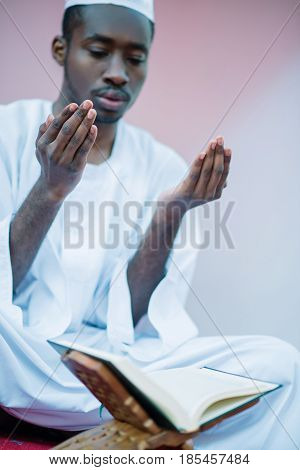 African Muslim Man Making Traditional Praying To God While Wearing A Traditional Cap Dishdasha