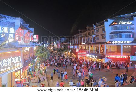 YANGSHOU CHINA - NOVEMBER 18, 2016: Unidentified people visit West street. West street is a main commercial street with restaurants bars and gift shops.