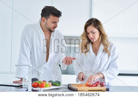 Happy couple cooking breakfast together in the kitchen.