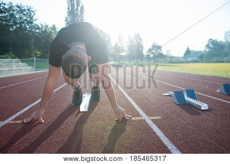 Sprinter leaving starting blocks on the running track. Explosive start