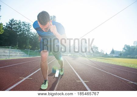 Sprinter leaving starting blocks on the running track. Explosive start