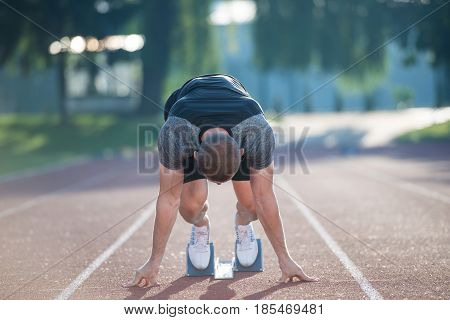 Sprinter leaving starting blocks on the running track. Explosive start