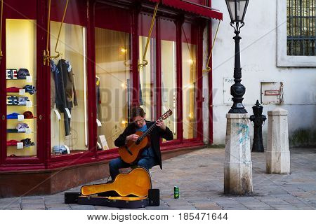 VIENNA-MARCH 30 2017. Street musitian sitting and playing guitar for tourists Kohlmarkt 11. March 30 2017 Vienna Austria.