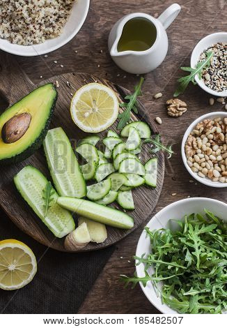 Ingredients for a spring detox salad. Quinoa green vegetables flax seeds nuts ginger. On wooden background top view