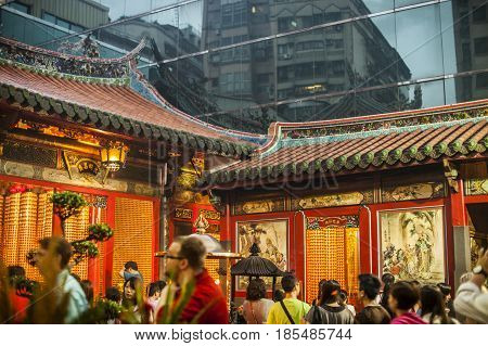 Taipei Taiwan - 6 October 2012: People praying and lighting incense at Longshan Temple in the center of the city