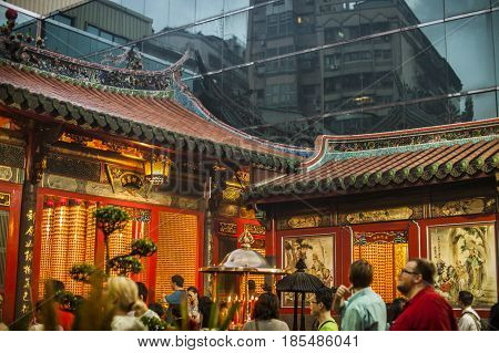 Taipei Taiwan - 6 October 2012: People praying and lighting incense at Longshan Temple in the center of the city
