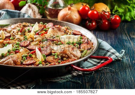 Traditional Paella With Chicken Legs, Sausage Chorizo And Vegetables Served In Paellera