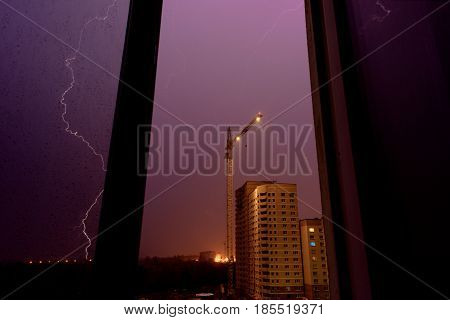 Thunderstorm, lightning stroke over the construction site, view from the window