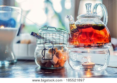 Close-up of modern glass teapot with tea inside in cafe