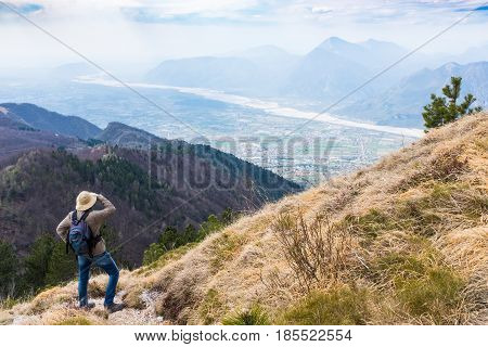 Hiker looking from Monte Chiampon to plain of Friuli-Venezia Giulia in Italy in spring
