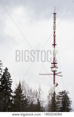 Telecommunication tower Antenna in cloudy sky, telephoto