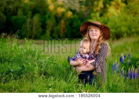 Sister hugs his younger brother, summer day