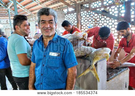 Bandar Abbas Hormozgan Province Iran - 16 april 2017: Portrait of a fish market worker on the background of workers cutting fresh fish.