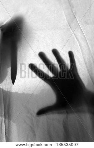 silhouette knife and hand threatening the victim